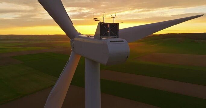 Alternative energy. Aerial view of windmills farm. Power energy production in USA. Landscape with wind turbines. Large wind turbines with blades in field aerial view bright orange sunset