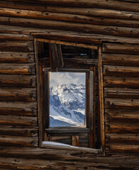 View of snow covered mountains thru window of abandoned building in  Colorado - 771106346