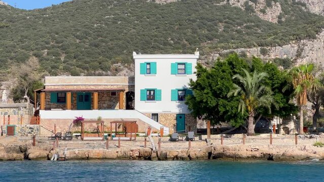 A very cute Kaş mansion with its own private beach, palm trees in the garden and tastefully painted walls. Picturesque bay in the resort town of Kaş. Antalya Province, Turkey
