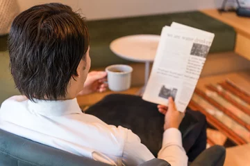 Foto op Plexiglas 朝家やホテルで英字新聞を読むスーツ姿のアジア人ビジネスマン  © buritora