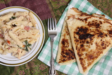 Plate of Pasta Carbonara With Italian Flat Bread on Rustic Table