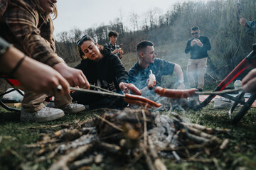 Group of friends grilling sausages over an open fire during a relaxing outdoor barbecue gathering...