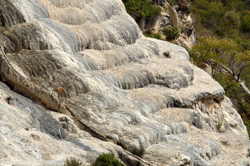 Tavertine rock formation in the shape of a waterfall on the side of a mountain at Hierve el Agua in...