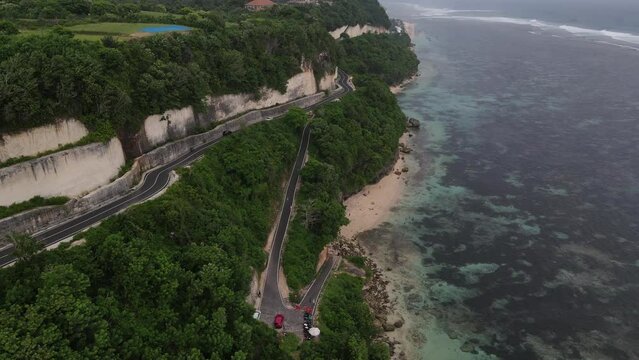Aerial view, cliffside asphalt road and sea located on Tanah Barak beach, Bali island, Indonesia.