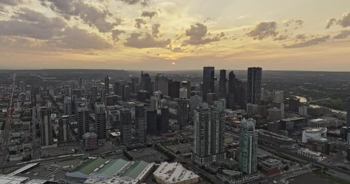 Calgary AB Canada Aerial v55 drone flyover Victoria park across East Village capturing cityscape of Beltline, Downtown Commercial and Eau Claire at sunset - Shot with Mavic 3 Pro Cine - July 2023