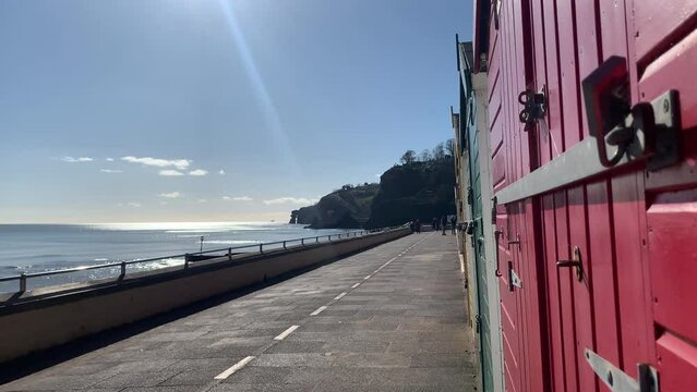 Tourism and coast of Devon with seaside huts and walkway. sea and shore and vacation in England UK 4K