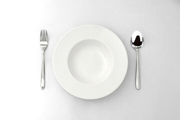 clearly white ceramic dish in the white background with a pairs of silver spoon