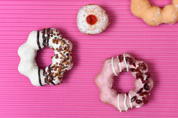 Different kind of doughnuts in pink and graphic style background