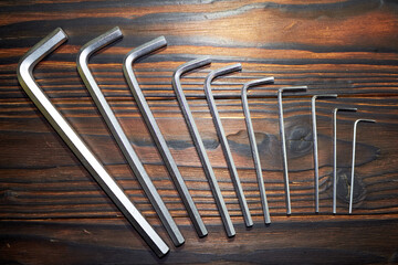 Set of hex key (Allen wrench or Allen key) of various sizes on a wooden table