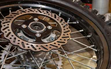 mountain bike parts removed close up in a garage during maintenance. wheel, chain, tire, engine and other elements
