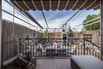 a plant-filled terrace with smooth metal furniture and wicker dividers for privacy with stairs with...