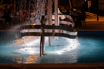 Colorful fountain with night light blurred background, Rimini resort in Italy