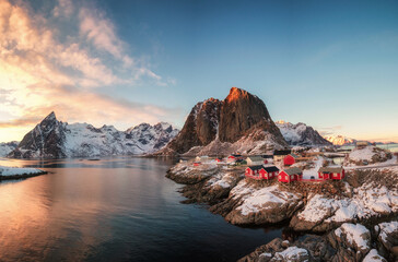 Red house fishing village with snow mountain at sunset