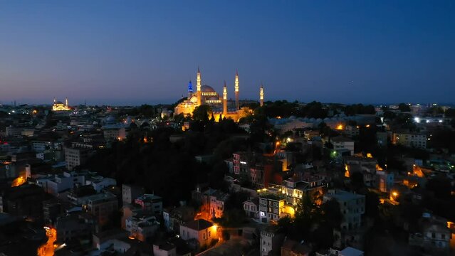 S&uuml;leymaniye Mosque built by Architect Sinan in 16th century in Istanbul, Turkey. Drone flies towards illuminated Suleymaniye Mosque on a Ramadan early morning. Aerial view
