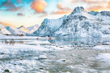 Fabulous frozen Flakstadpollen and Boosen fjords with cracks on ice during sunrise with Hustinden...