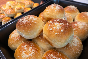 Golden-brown buns in a metal tray, bakery fresh.