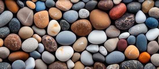 A closeup view of a pile of various colored and sized rocks, including cobblestones and pebbles, showcasing the natural beauty of building materials in art - obrazy, fototapety, plakaty