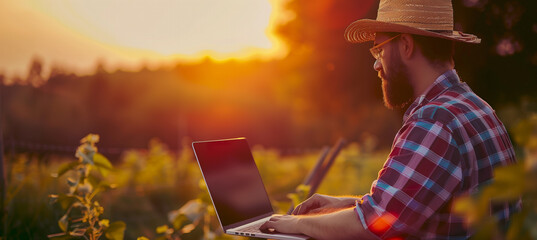Modern farmer using a laptop computer with blurred background