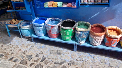 Sacks of powdered dyes on a bench in front of a shop in Chefchaouen, Morocco
