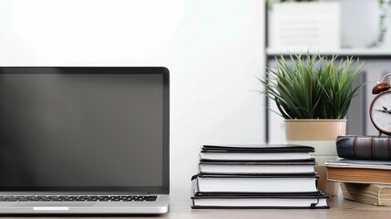 Laptop with stack of folders on table on white background