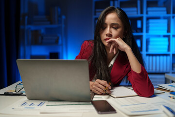 Asian businesswoman is tired, sleepy and bored from sitting at a desk for a long time working on a laptop computer. Problematic financial paperwork Office syndrome concept.