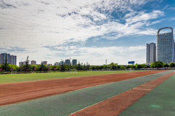 The unmanned outdoor football stadium is located on the university campus, with clear skies