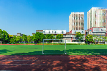 The unmanned outdoor football stadium is located on the university campus, with clear skies