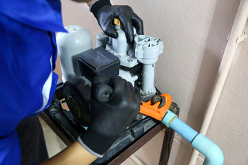 Technician plumber using a wrench to repair a water pump pipe. Concept of maintenance, fix water...