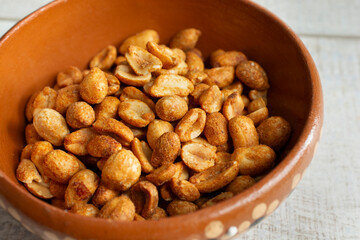 A view of a clay dish of roasted peanuts.
