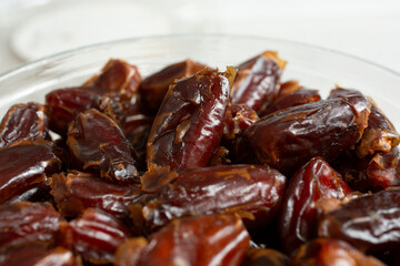 A closeup view of a container full of deglet noor dates.
