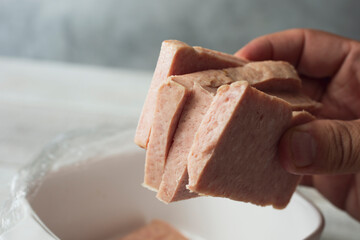 A view of a hand holding a stack of spiced hand slices.