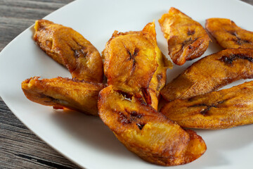 A closeup view of a plate of fried plantains.