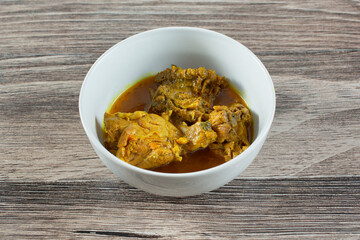 A view of a bowl of curry chicken.