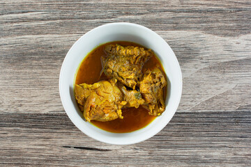 A top down view of a bowl of curry chicken.