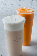 A view of a white peach oolong milk tea and a Thai tea.