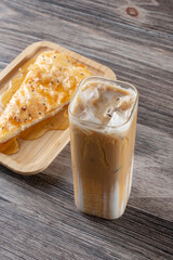 A view of a cold latte drink and a slice of sabayah.
