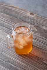 A view of an orange colored herbal iced tea drink.