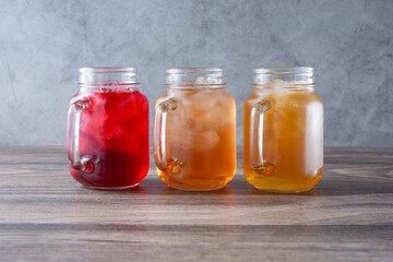 A view of three mason jars filled with iced teas.