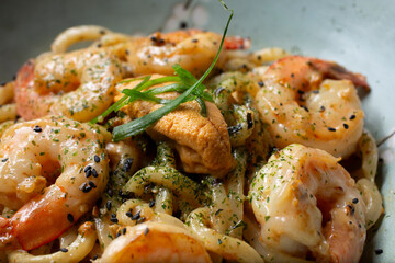 A closeup view of a bowl of uni and shrimp udon.