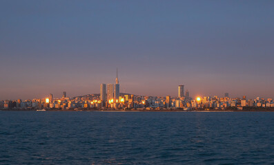 Fototapeta premium Sunset view of coastline of Istanbul. Orange highlights on modern architecture