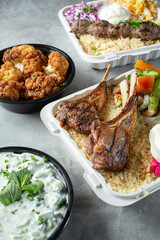 A view of several Mediterranean entrees, featuring a lamb chop entree.