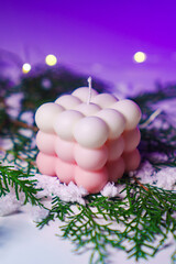 Cute white and pink Bubble candles on purple background. 
