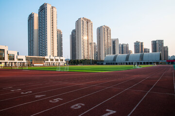 In the city, sunlight shines on outdoor sports stadiums, and outside the stadiums are towering skyscrapers
