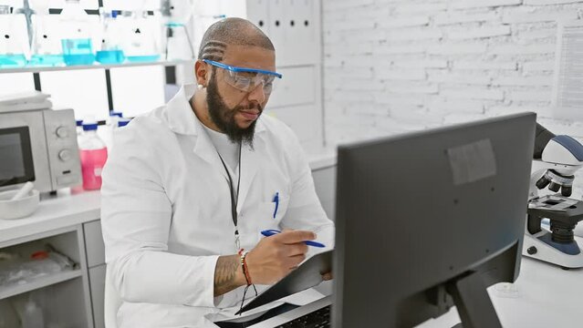 A bearded scientist analyzes data on a computer in a modern laboratory setting.