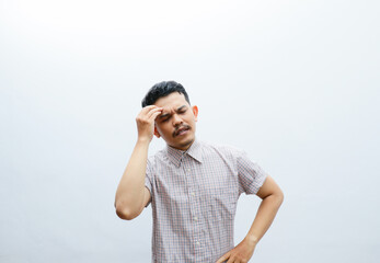 Fototapeta premium an asian man shows a dizzy expression and holds his head