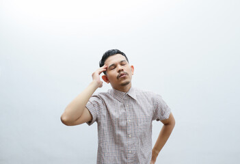 an asian man shows a dizzy expression and holds his head