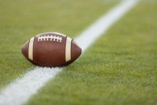 American football resting on a first down line during  an American football game. The ball is ready to be snapped to start a new play. Lots of copy space