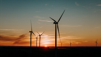 Aerial view of sun rising over wind farm generating clean electricity