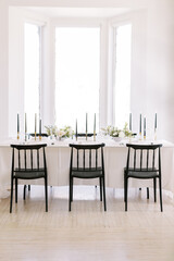 Fototapeta na wymiar Serene wedding reception table with elegant black chairs
