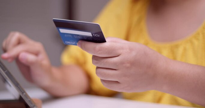 Doing an online transaction to purchase some things using a mobile tablet and a credit card to pay for the purchases.